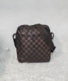 Louis Vuitton Monogram Beaubourg messenger bag. Features the signature damier ebene exterior and top zip closure that opens to a brown fabric lined interior and flat adjustable strap. Please view pictures and read descriptions before purchasing. Measurement: H - 24cm x W - 25cm x D - 5cm The exterior and interior are good. Edges and corners have some rubbing and darkening. Fading on strap and discolouration on interior Hardware is slightly tarnished. A bit sturdy. No dust bag, no damage, no rips Interior Hardware, View Pictures, Brown Fabric, Damier Ebene, Authentic Louis Vuitton, Purses And Handbags, Louis Vuitton Monogram, Messenger Bag, Shoulder Bags