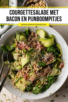 a white bowl filled with cucumbers, beans and sprouts on top of a table