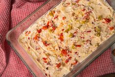 a casserole dish with vegetables in it on a red and white table cloth