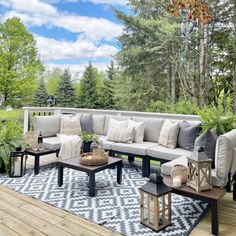 an outdoor living area with couches, tables and potted plants on the deck