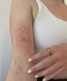 a woman's arm with a small tattoo on the left side of her arm