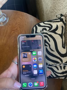 a person holding an iphone in their hand with the screen turned on and icons displayed