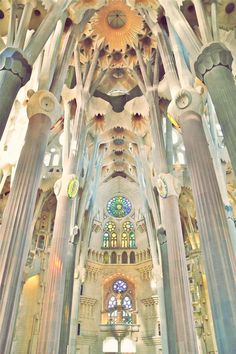 the inside of a large cathedral with many columns and stained glass windows on each side