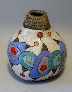 a ceramic vase with colorful designs on it