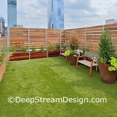 a rooftop garden with grass and wooden benches