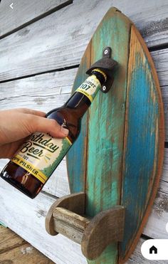 a person holding a beer bottle in front of a surfboard