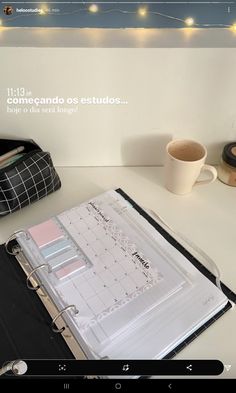 a binder sitting on top of a desk next to a cup