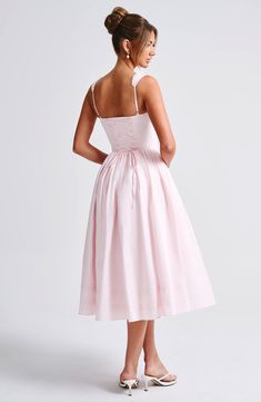 a woman in a pink dress looking back