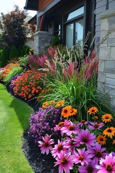 colorful flower garden in front of a house with grass and flowers growing on the side