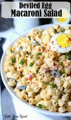 a white bowl filled with macaroni salad and an egg