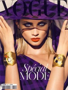 a magazine cover with a woman in purple and gold jewelry on her arm, wearing a hat