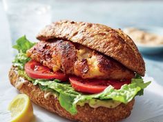 a chicken sandwich with tomatoes and lettuce