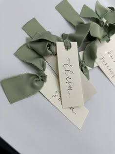 two tags with green ribbons attached to them