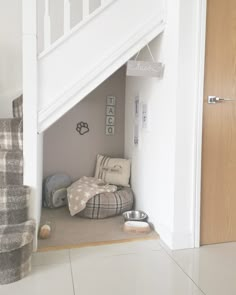 there is a dog bed under the stairs