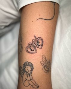 a tattoo on the arm of a woman with pictures of hearts and angels around her