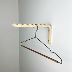 a clothes hanger with a wooden stick hanging from it's side on a wall