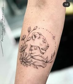 a tattoo on the arm of a woman with flowers and a dog's head