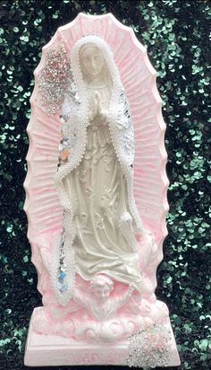 a statue of the virgin mary holding an umbrella