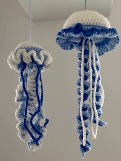 two blue and white crocheted jellyfish ornaments hanging from the ceiling in a room