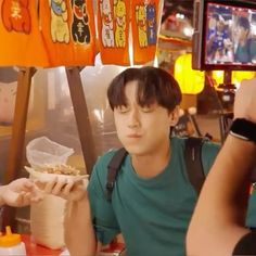 two people sitting at a table with food in front of them and one person taking a photo