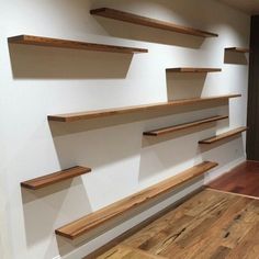 empty wooden shelves are lined up against the wall in an empty room with hard wood flooring