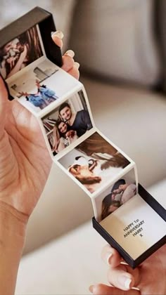 a woman holding an open photo book with pictures on it's side and the cover opened