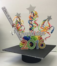 a graduation cap with streamers and confetti in the shape of a tree