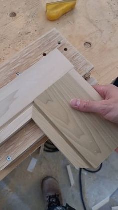 a person is holding some wood in their hand and working on something with the help of a drill