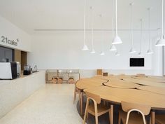 a large wooden table sitting in the middle of a room with lots of chairs around it