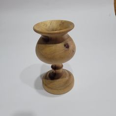 a wooden vase sitting on top of a white table