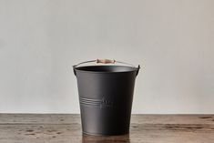 a black bucket sitting on top of a wooden table