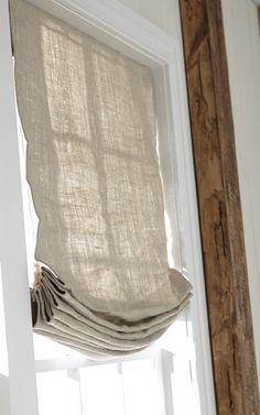 a close up of a window with a curtain hanging from it's rodulage