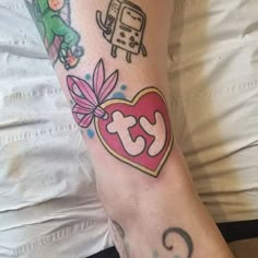 a woman's arm with tattoos on it and an image of a cat in the shape of a heart