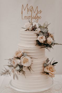 a white wedding cake with flowers on top