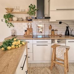 a kitchen with white cabinets and wooden counter tops, along with yellow lemons on the floor