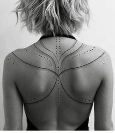 the back of a woman's neck with lines drawn on it and dots all over her body