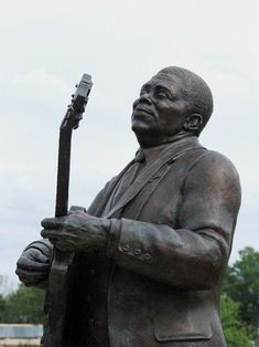 a statue of a man holding a guitar