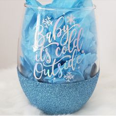 a baby is cold outside wine glass filled with blue tissue paper and snowflakes