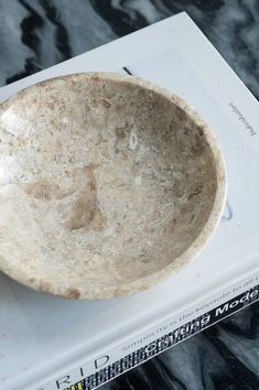 a stone bowl sitting on top of a book