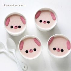 four little cups with pink and black animal faces in them