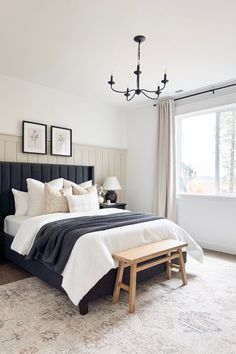 a bedroom with a large bed and two pictures hanging on the wall above it's headboard