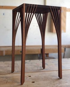 a wooden table sitting on top of a hard wood floor covered in lots of lines