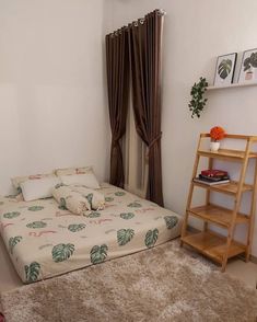 a bed sitting next to a window in a bedroom on top of a brown rug