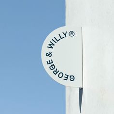 a sign on the side of a building that says george & willy in blue letters