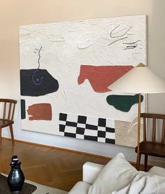 a living room filled with furniture and a large painting on the wall above a table