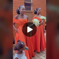 two women in orange dresses standing next to each other and one is holding a bouquet