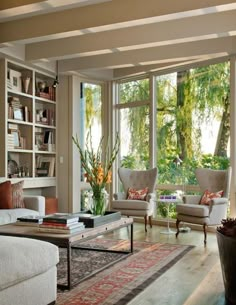 a living room filled with lots of furniture and large windows covered in bookshelves