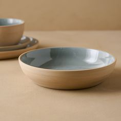 two bowls sitting on top of a table next to each other with one bowl in the middle