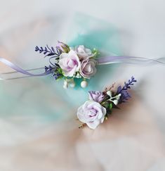 two flowers with purple and white colors on them sitting next to each other in front of a light blue background