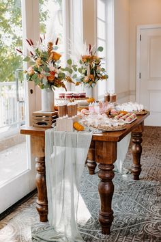 a table with flowers and desserts on it